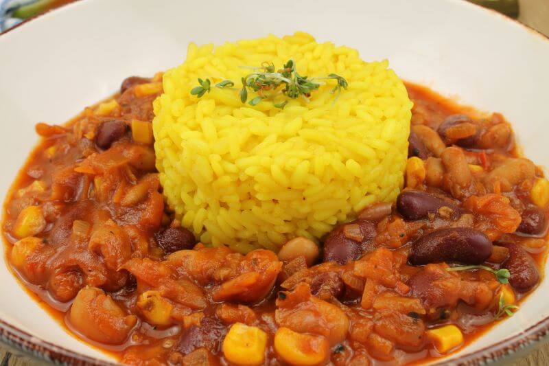 Chilli sin carne mit einer Portion Reis in der Mitte des Tellers.