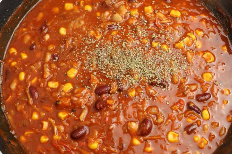 Das Chilli sin carne wird noch mit getrockneten Kräutern abgeschmecktt