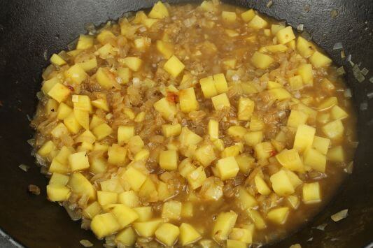 Kartoffeln und Zwiebeln mit Brühe ablöschen. Kartoffeln und Zwiebeln mit Brühe ablöschen.