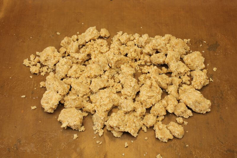 rohen Crumbleteig auf Blech verteilen rohen Crumbleteig auf Blech verteilen